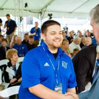 President Haas shaking hands with a guest at the Jamie Hosford Football Center dedication.